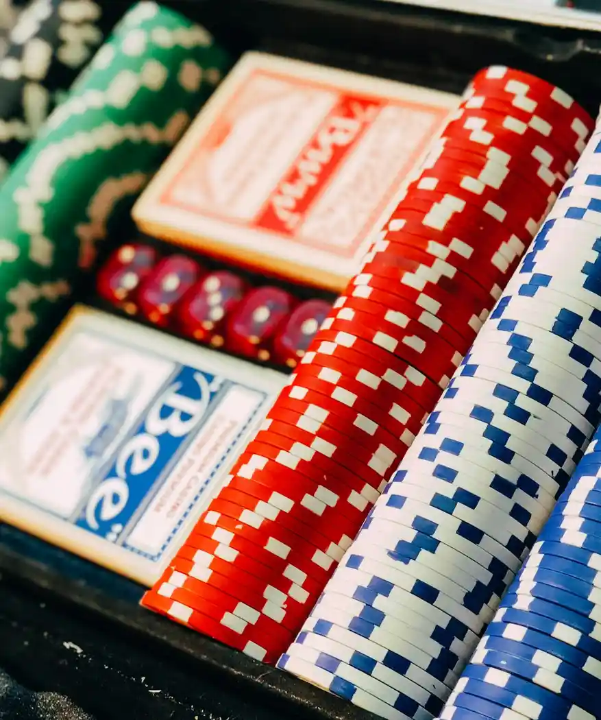 A case of club chips and playing cards on a dark table